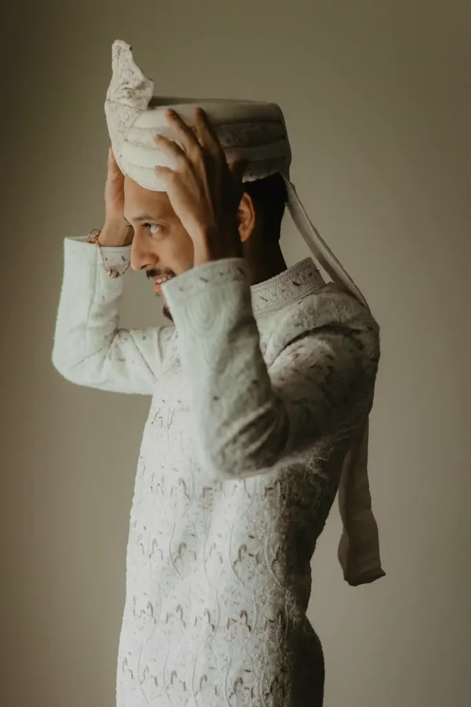 A groom having his turban tied on the morning of the wedding