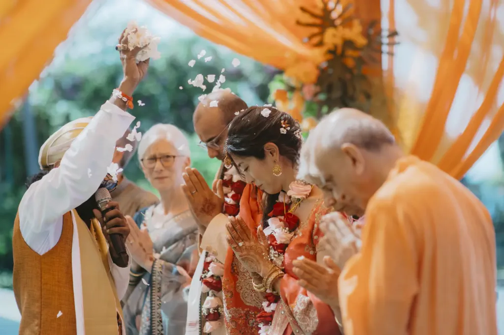 Family throwing petals and rice over the couple in blessing