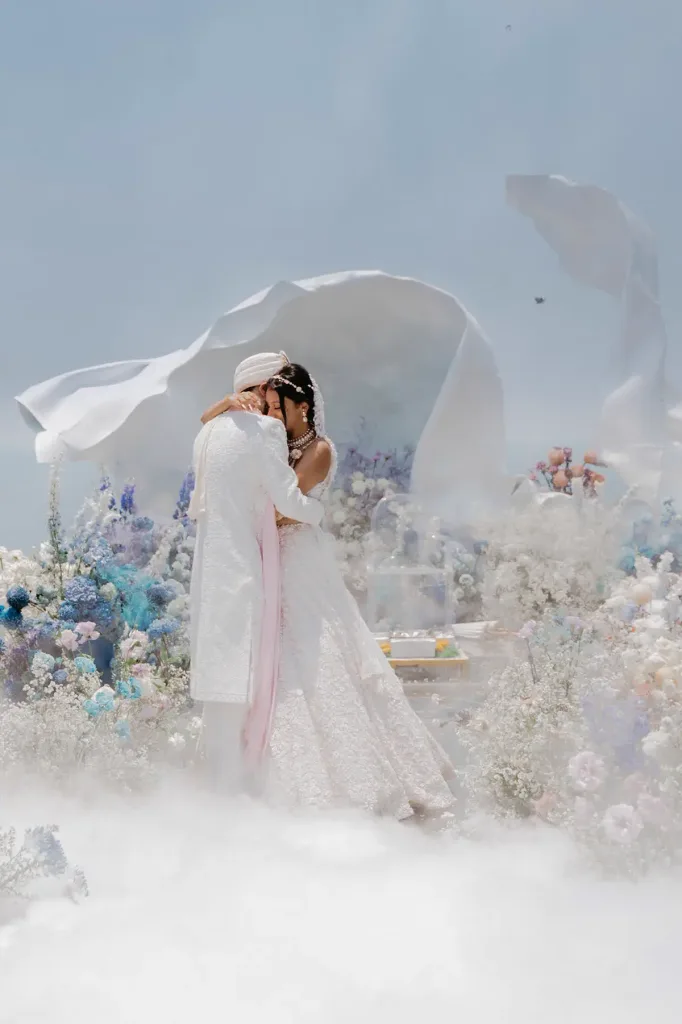 A quiet moment between the couple beneath a floating veil