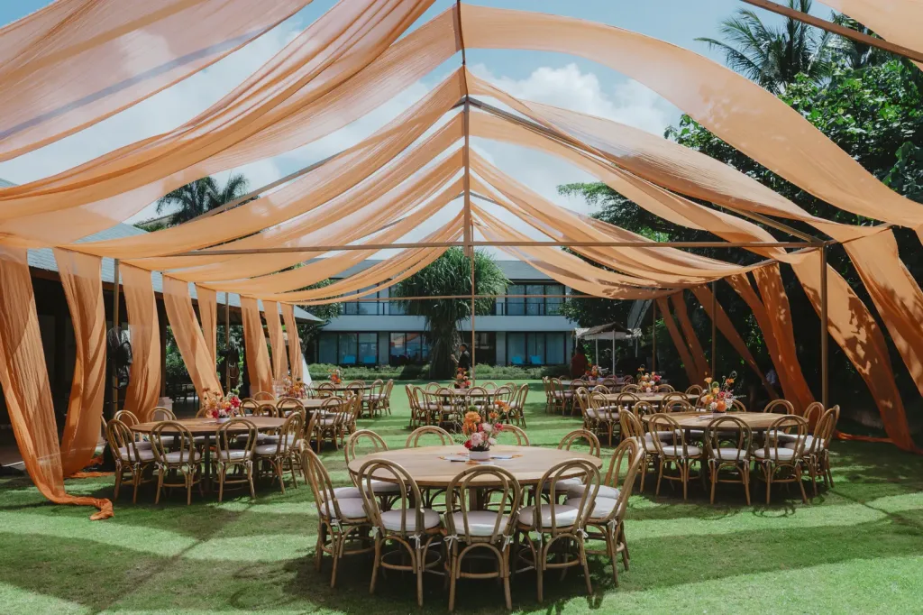 The reception laid out beneath a draped canopy on the lawn