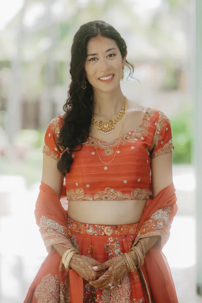 Portrait of the bride in coral silk and gold jewellery
