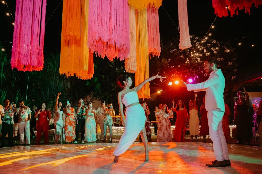 Guests dancing under hanging fringe installations at a sangeet night